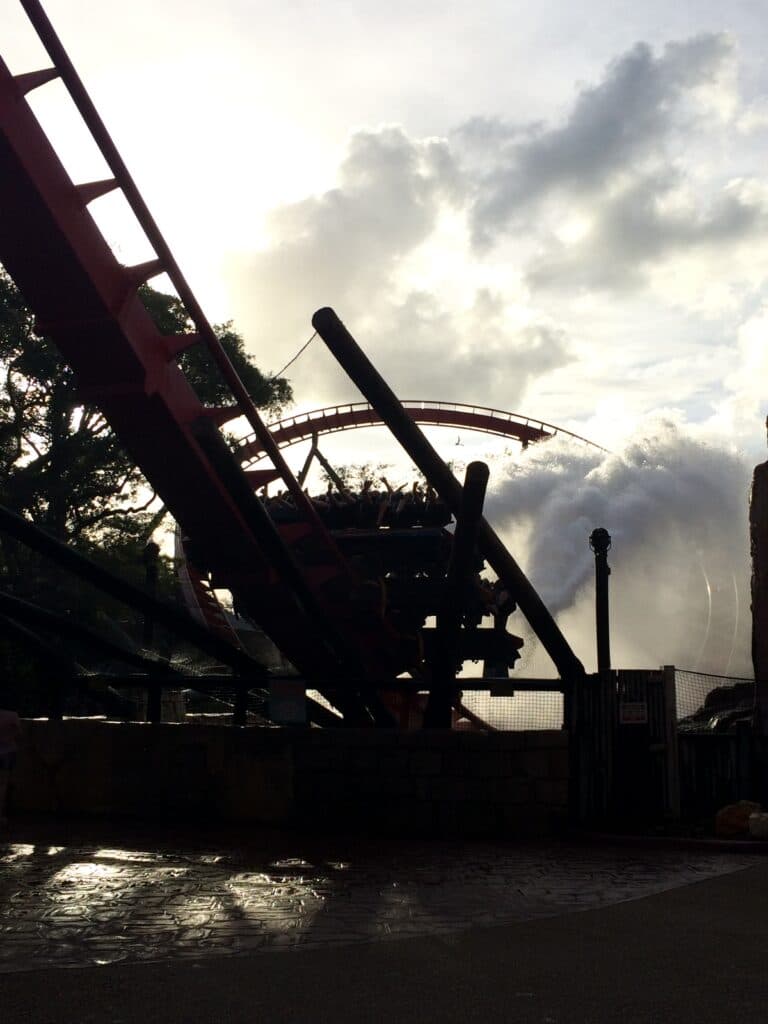 Montanha russa SheiKra no parque Busch Gardens, em Tampa, após uma de suas descidas com água subindo como efeito. Ao fundo é possível ver a curva bem acentuada que a montanha russa faz, e também o céu com muitas nuvens