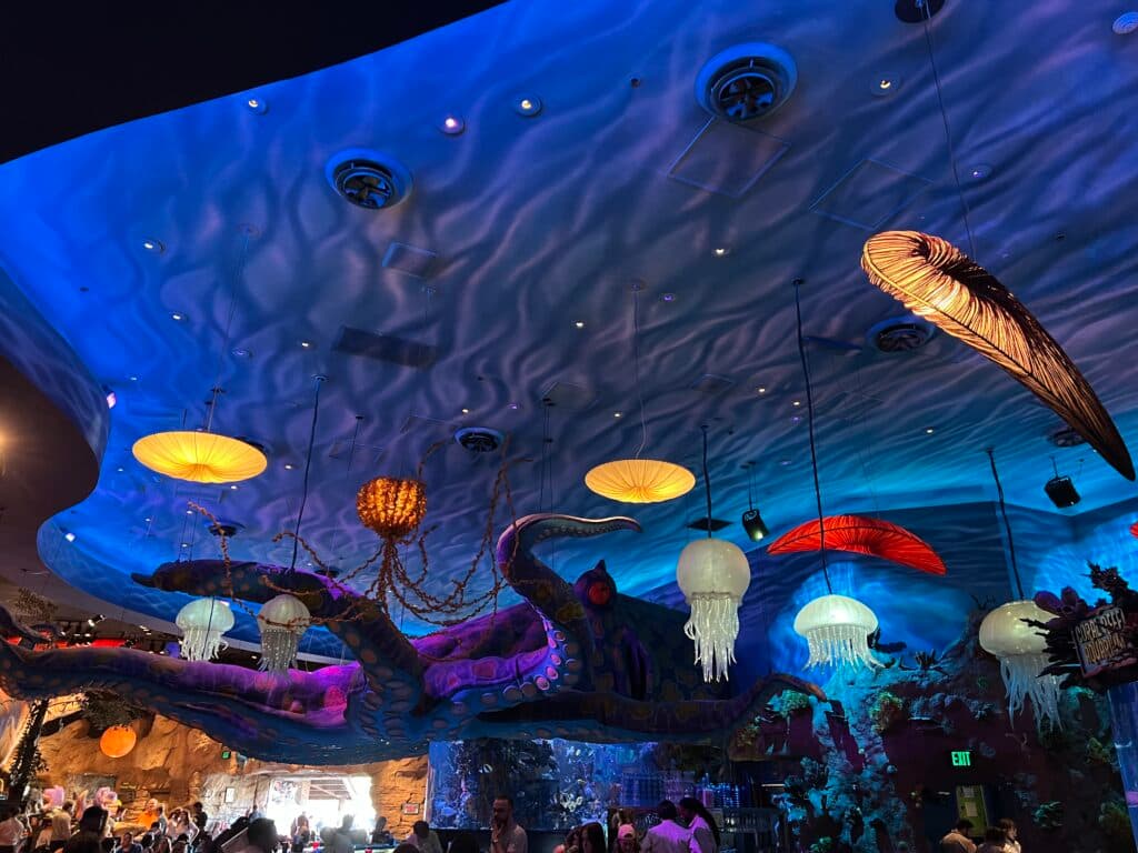 Teto do restaurante T-Rex, localizado em Disney Springs, centro comercial do complexo da Walt Disney World Resort em Orlando. A foto mostra um polvo gigante pendurado no teto, bem como pequenas águas vivas e outras criaturas marinhas