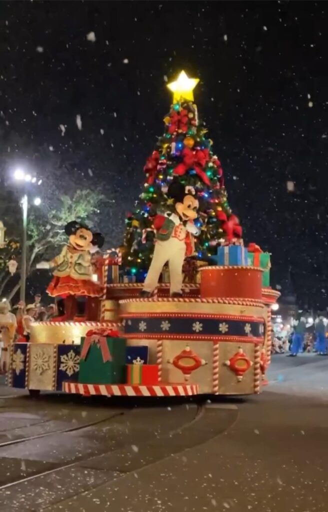 mickey e minnie em um carro alegorico com uma arvore de natal e presentes durante a festa de natal do magic kingdom na disney a mickeys very merry christmas parade