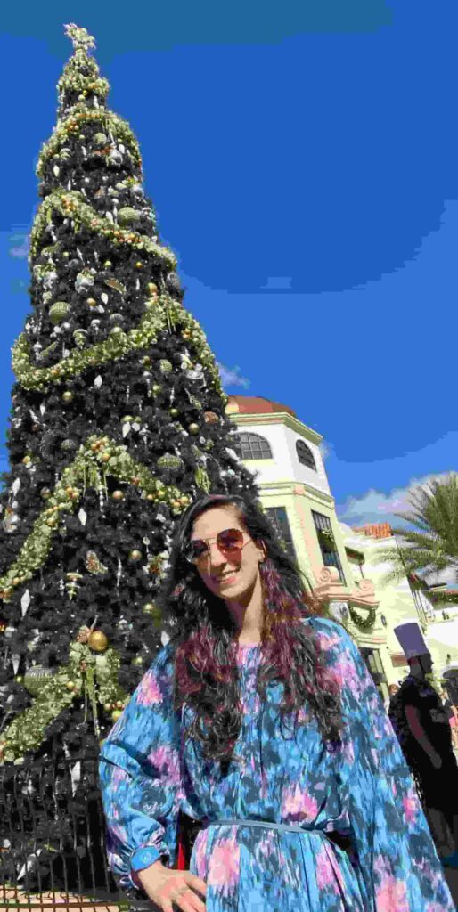 foto de mulher em frente uma arvore de natal da trilha natalina em disney springs